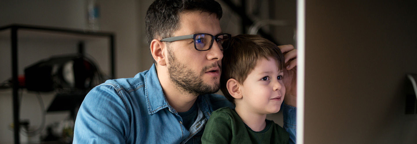 working father studying with his son is his lap